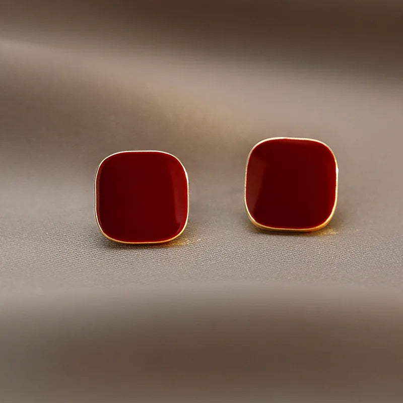 Red enamel studs with a gold border.