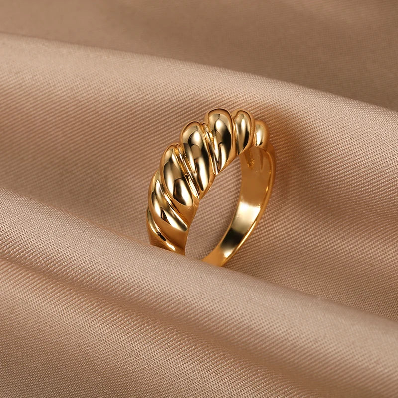 A chunky gold ring with a unique wavy texture.