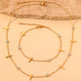 A set of two gold necklaces with multiple small crosses and clear crystals.