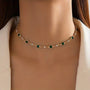 A dainty gold choker with green and clear crystals.