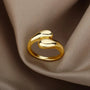 A gold ring with two curved, organic shapes.