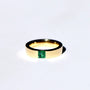 A gold ring with a square emerald gemstone set in the center.