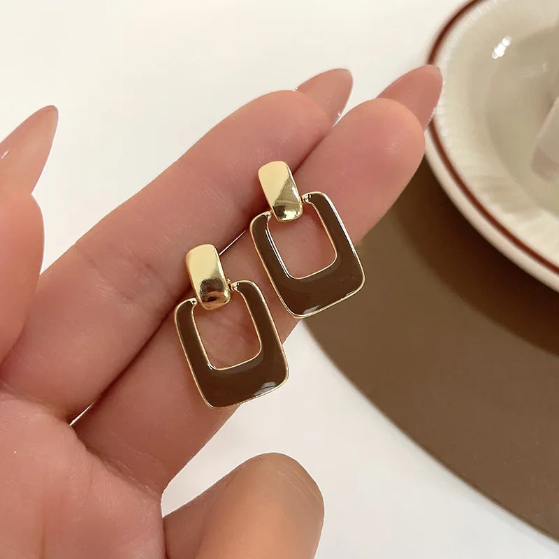 Minimalist earrings with a square shape and a hollow center.