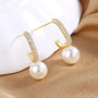 A pair of glamorous pearl drop earrings with crystal accents.