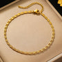 A gold chain link anklet with a delicate design.