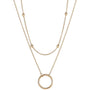 A gold necklace with a circle pendant and two layers of chain.