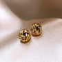 A pair of twisted gold knot stud earrings.