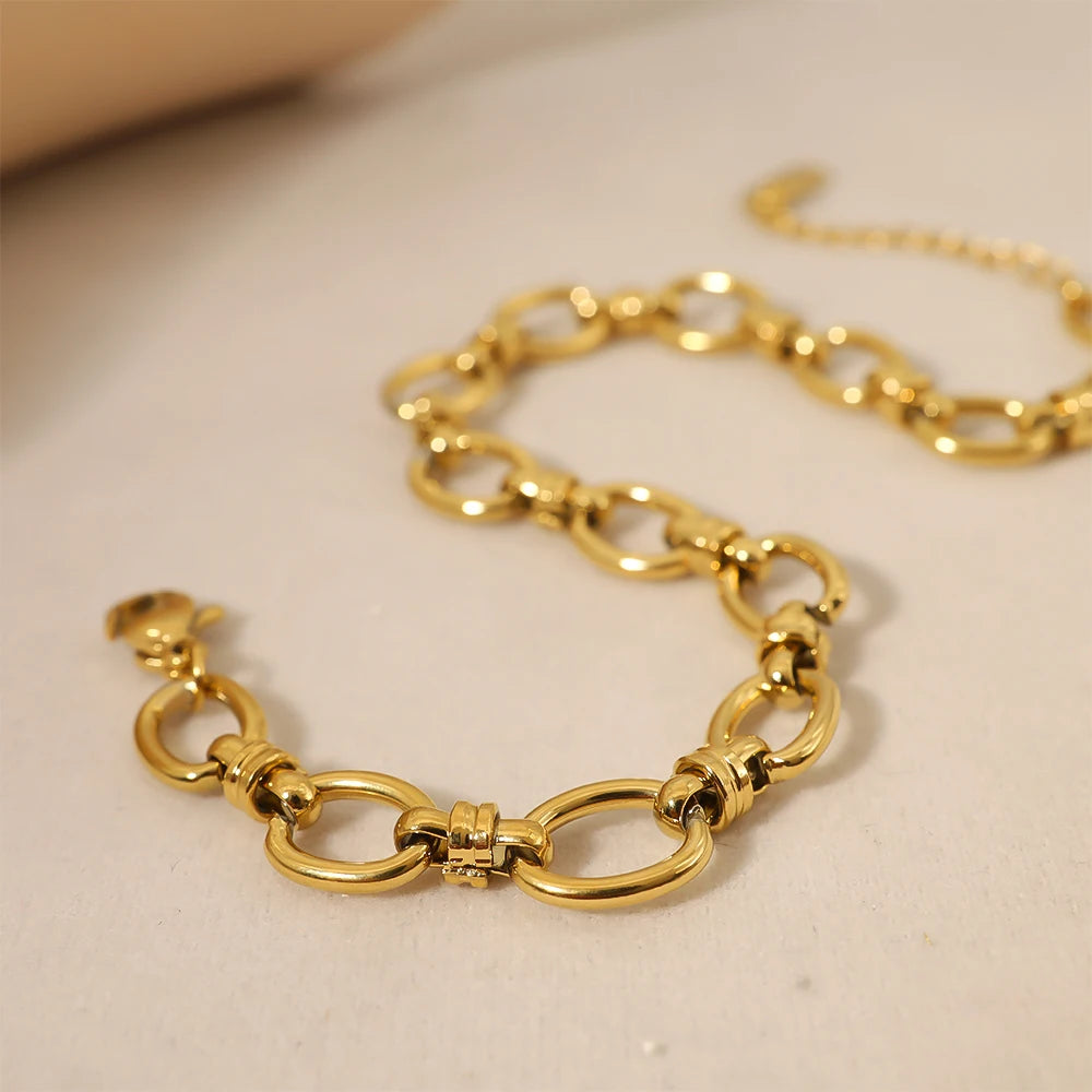 A gold chain bracelet with oval links intertwined. The bracelet has a clasp closure.
