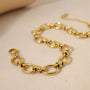 A gold chain bracelet with oval links intertwined. The bracelet has a clasp closure.
