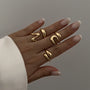 A set of four gold rings with a simple and elegant wavy design.