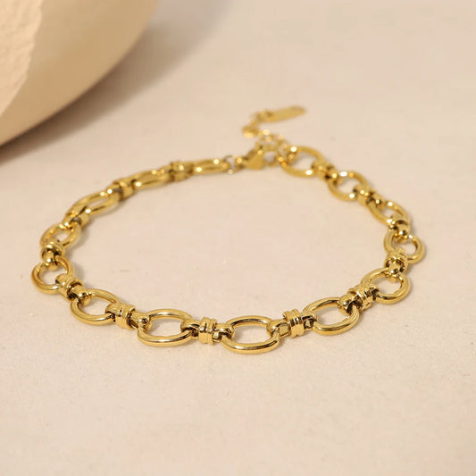 A gold chain bracelet with oval links intertwined. The bracelet has a clasp closure.