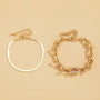 A set of two dainty gold bracelets, one with a chain link design and the other with a flat design.