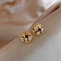 A pair of gold knot stud earrings with a simple and elegant design.