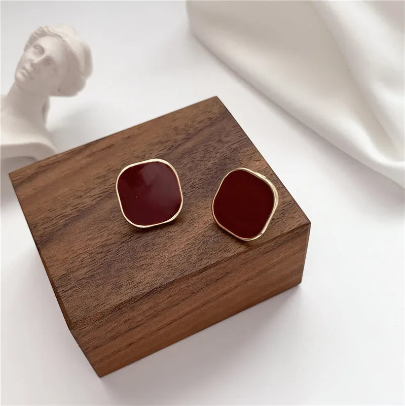 Red and gold earrings with a simple and elegant design.