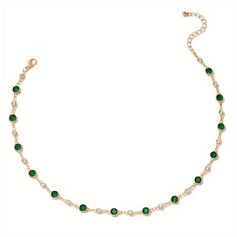 A simple gold choker with green and clear crystal accents.