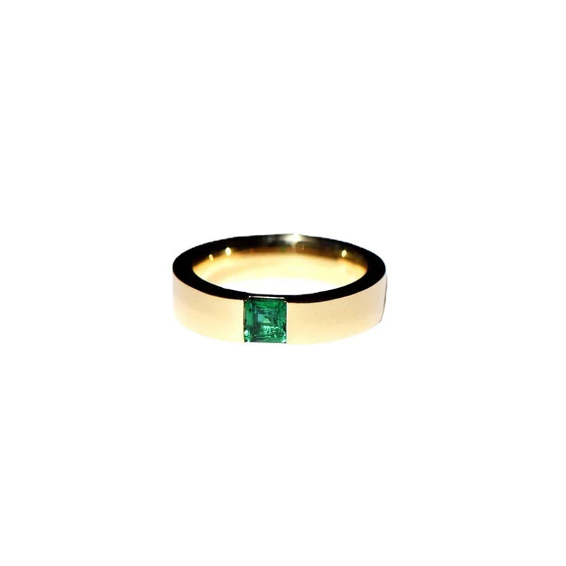 A simple gold ring with a square emerald set in the center.