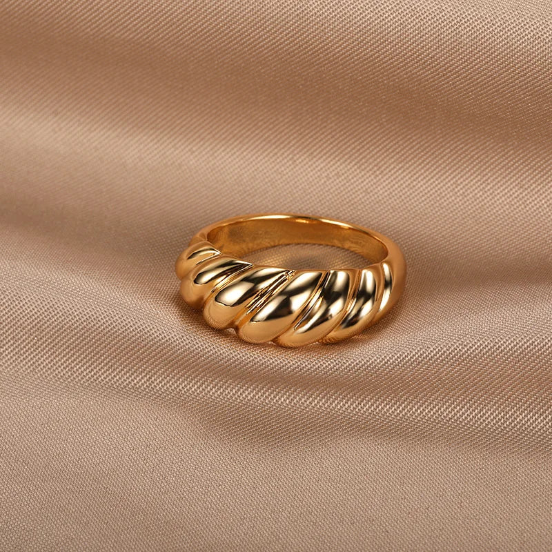 A gold ring with a textured, wavy design.